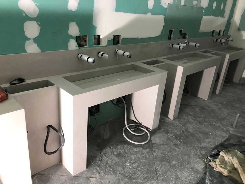 Baño público en obra con las encimeras de lavabo recién colocadas